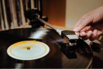 This is a photo of an artist listening to a vinyl record after having signed a record contract with a label.