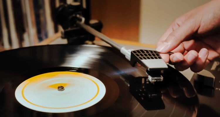 This is a photo of an artist listening to a vinyl record after having signed a record contract with a label.